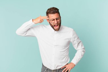 Genç yakışıklı adam mutsuz ve stresli görünüyor, intihar jesti silah işareti yapıyor.