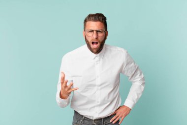 Genç yakışıklı adam sinirli, sinirli ve sinirli görünüyor.