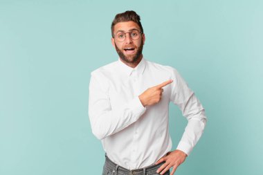 Genç yakışıklı adam heyecanlı ve şaşırmış görünüyor.