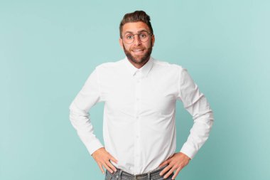 Genç yakışıklı adam mutlu ve hoş bir şekilde şaşırmış görünüyor.