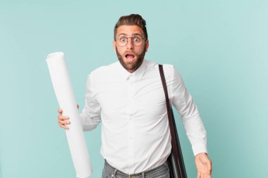 Genç ve yakışıklı bir adam çok şaşırmış ya da şaşkın görünüyor. mimar konsepti