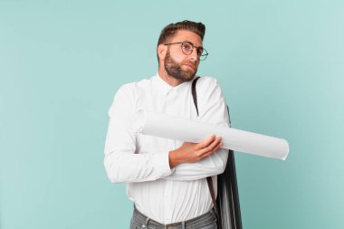 Genç yakışıklı adam omuz silkiyor, kafası karışık ve kararsız. mimar konsepti