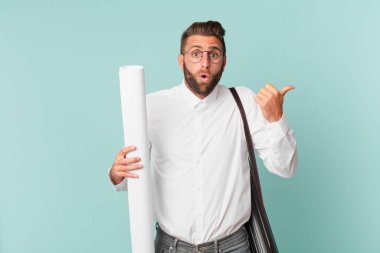 İnanamadığı için şaşırmış genç ve yakışıklı bir adam. mimar konsepti