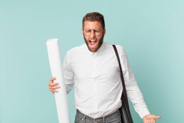 Genç yakışıklı adam agresif bir şekilde bağırıyor, çok kızgın görünüyor. mimar konsepti