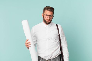 Kafası karışmış ve kafası karışmış genç yakışıklı bir adam. mimar konsepti