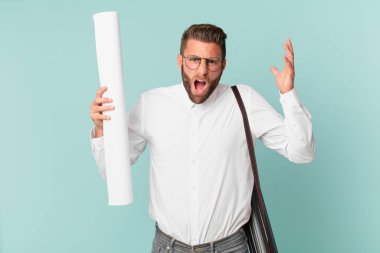 Genç yakışıklı adam ellerini havaya kaldırarak çığlık atıyor. mimar konsepti