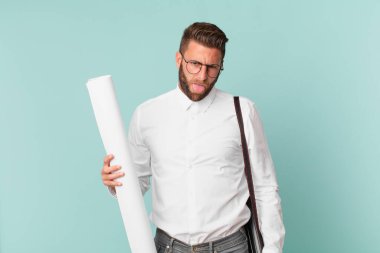 Genç ve yakışıklı bir adam tiksinmiş ve sinirlenmiş hissediyor ve dilini dışarı çıkarıyor. mimar konsepti