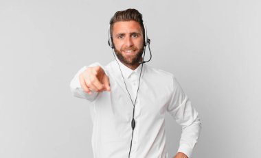 Genç ve yakışıklı bir adam kamerayı işaret ederek seni seçiyor. tele pazarlama kavramı