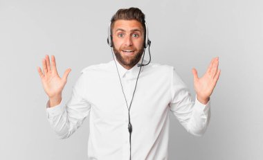 Genç yakışıklı adam kendini mutlu hissediyor ve inanılmaz bir şeye hayret ediyor. tele pazarlama kavramı