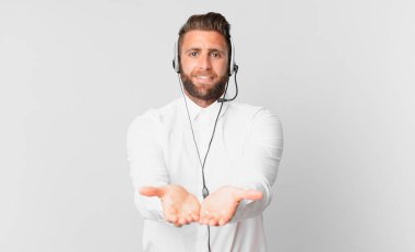 Genç ve yakışıklı bir adam arkadaşça gülümsüyor ve bir konsept sunuyor. tele pazarlama kavramı