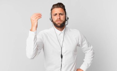 Genç yakışıklı adam kapiş ya da para hareketi yapıyor, sana ödemeni söylüyor. tele pazarlama kavramı