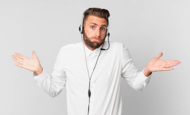 Genç yakışıklı adam şaşkın, şaşkın ve şüpheci hissediyor. tele pazarlama kavramı