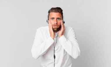 Genç ve yakışıklı bir adam şok olmuş ve korkmuş hissediyor. tele pazarlama kavramı