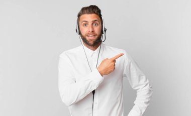 Genç yakışıklı adam heyecanlı ve şaşırmış görünüyor. tele pazarlama kavramı