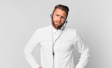 Genç yakışıklı adam şaşkın ve şaşkın hissediyor. tele pazarlama kavramı