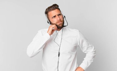 Genç yakışıklı düşünen, kuşkulu ve kafası karışık bir adam. tele pazarlama kavramı