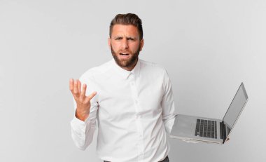 Genç ve yakışıklı bir adam sinirli, sinirli ve hayal kırıklığına uğramış görünüyor.