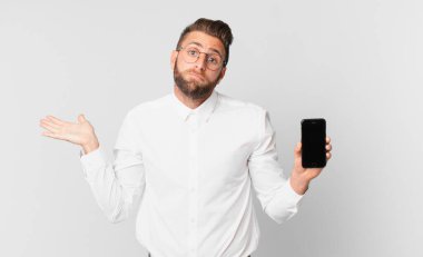 Genç yakışıklı adam şaşkın, şaşkın, şüpheci ve hücrede tutuluyor.