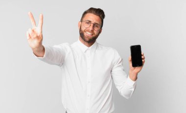 Genç yakışıklı adam gülümsüyor ve mutlu görünüyor, zafer ya da barış işareti yapıyor ve bir hücrede tutuluyor.