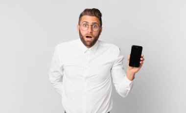 Genç ve yakışıklı bir adam çok şaşırmış ya da şaşırmış görünüyor.