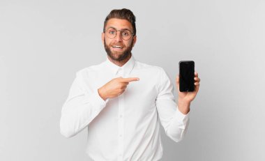 Genç ve yakışıklı bir adam heyecanlı ve şaşırmış görünüyor.