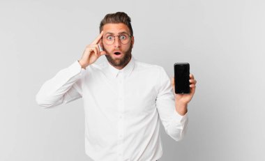 Genç yakışıklı adam şaşırmış görünüyor, yeni bir düşünce, fikir ya da konsept fark ediyor ve bir hücre tutuyor.