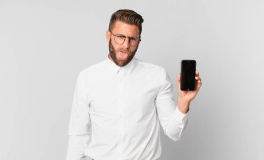 Genç yakışıklı adam, tiksinmiş ve rahatsız olmuş hissediyor. Dilini dışarı çıkarıyor ve bir hücreyi tutuyor.