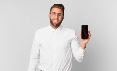 Genç yakışıklı adam mutlu görünüyor ve hoş bir şekilde şaşırmış ve hücrede tutuluyor.