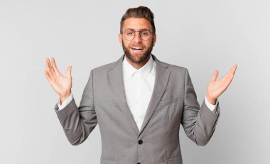 Genç yakışıklı adam kendini mutlu hissediyor ve inanılmaz bir şeye hayret ediyor. iş kavramı