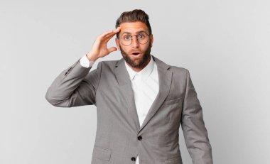 Genç yakışıklı adam mutlu, şaşkın ve şaşırmış görünüyor. iş kavramı