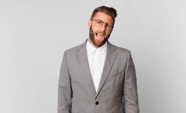 young handsome man with cheerful and rebellious attitude, joking and sticking tongue out. business concept