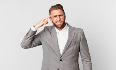 young handsome man feeling confused and puzzled, showing you are insane. business concept