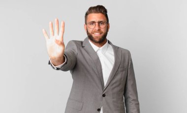young handsome man smiling and looking friendly, showing number four. business concept