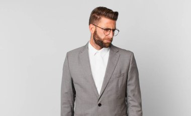 young handsome man feeling sad, upset or angry and looking to the side. business concept