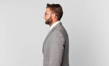 young handsome man on profile view thinking, imagining or daydreaming. business concept