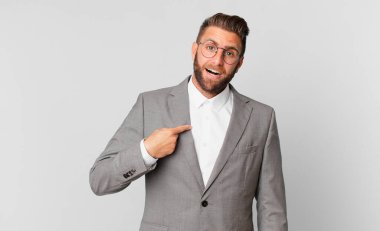 Şok olmuş ve ağzı açık, kendini işaret eden genç ve yakışıklı bir adam. iş kavramı