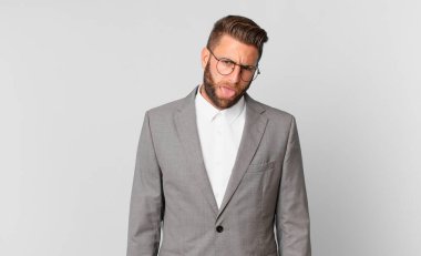 Genç ve yakışıklı bir adam tiksinmiş ve sinirlenmiş hissediyor ve dilini dışarı çıkarıyor. iş kavramı