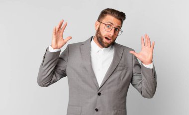 Genç yakışıklı adam ellerini havaya kaldırarak çığlık atıyor. iş kavramı