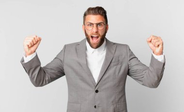 Genç yakışıklı adam sinirli bir ifadeyle agresif bir şekilde bağırıyor. iş kavramı