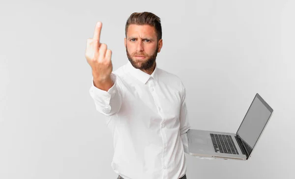 Młody Przystojny Mężczyzna Uczucie Wściekły Zirytowany Buntowniczy Agresywny Trzymając Laptop — Zdjęcie stockowe