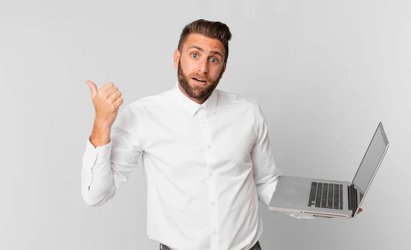 Young Handsome Man Looking Astonished Disbelief Holding Laptop — Φωτογραφία Αρχείου