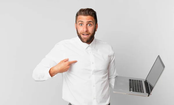 Young Handsome Man Feeling Happy Pointing Self Excited Holding Laptop — Φωτογραφία Αρχείου