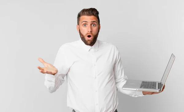 Young Handsome Man Feeling Extremely Shocked Surprised Holding Laptop — Φωτογραφία Αρχείου