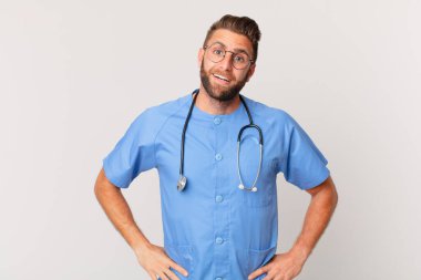 young handsome man looking happy and pleasantly surprised. nurse concept