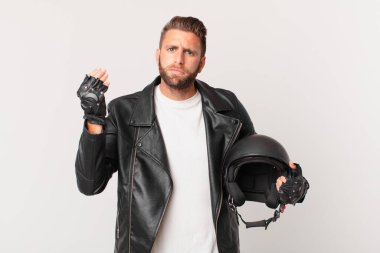 Genç yakışıklı adam kapiş ya da para hareketi yapıyor, sana ödemeni söylüyor. Motosiklet kaskı konsepti