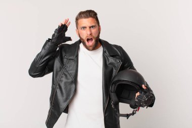 young handsome man screaming with hands up in the air. motorbike helmet concept