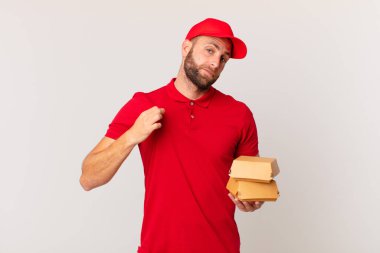 young handsome man looking arrogant, successful, positive and proud burger delivering concept