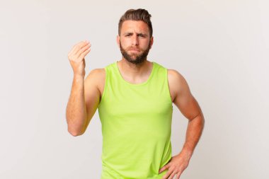 Genç yakışıklı adam kapiş ya da para hareketi yapıyor, sana ödemeni söylüyor. fitness konsepti