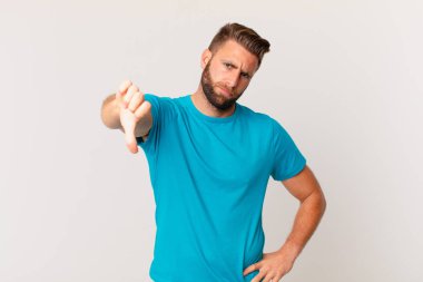 Genç ve yakışıklı bir adam kendini kötü hissediyor, baş parmağını kaldırıyor. fitness konsepti