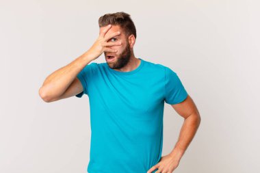 Genç, yakışıklı adam şok olmuş, korkmuş ya da korkmuş görünüyor. fitness konsepti